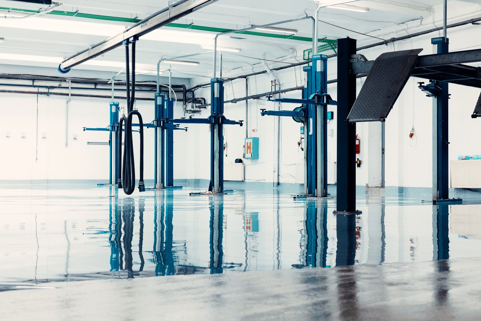 Clean automotive repair shop with reflective epoxy flooring and lifts