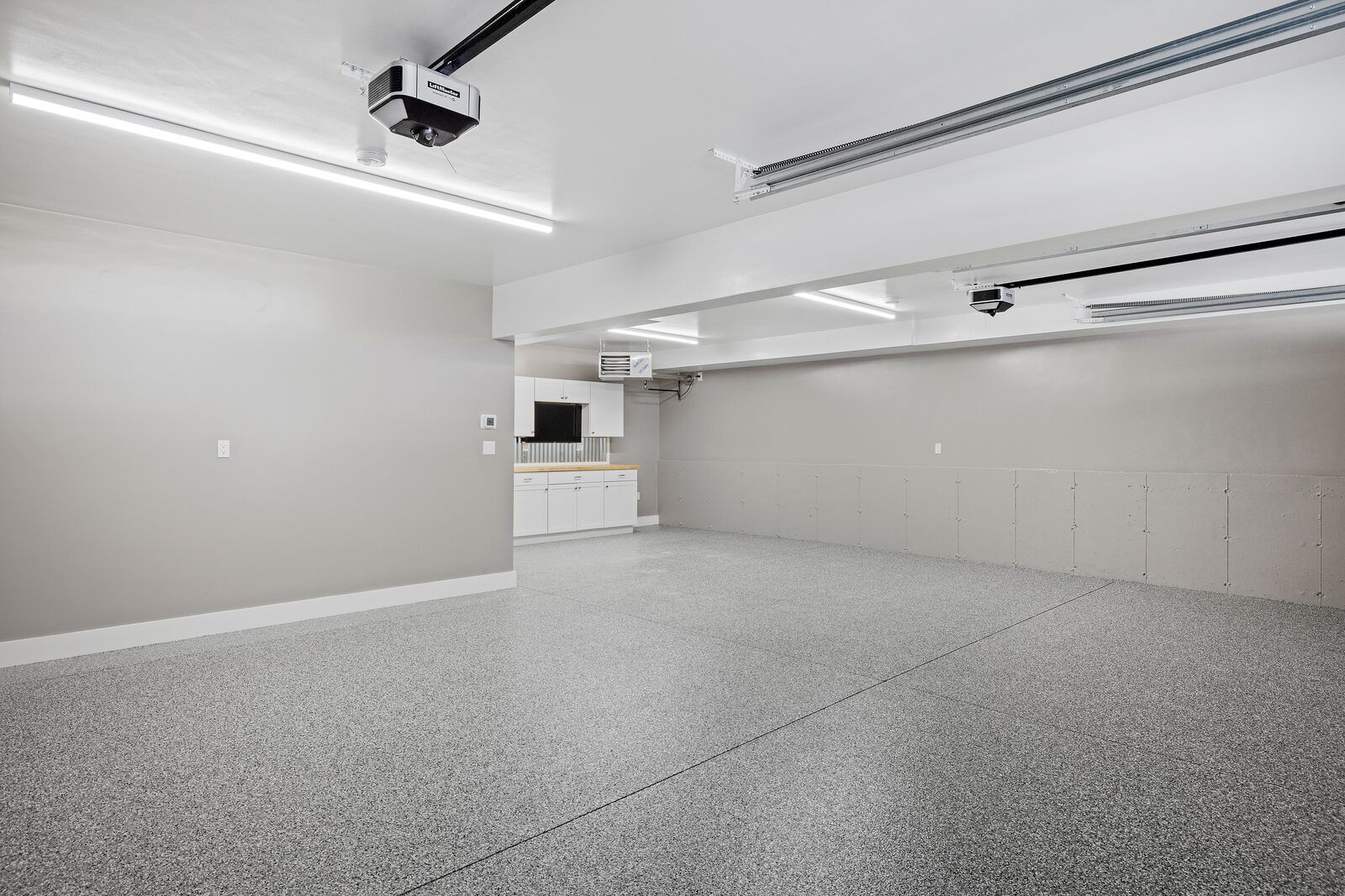 Freshly coated flake garage floor with white cabinets