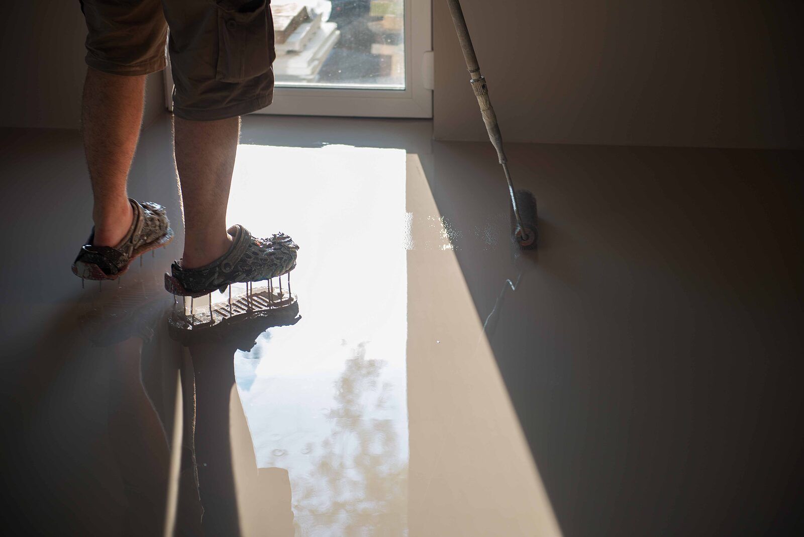 Topcoat being rolled with spiked shoes across a fresh base coat