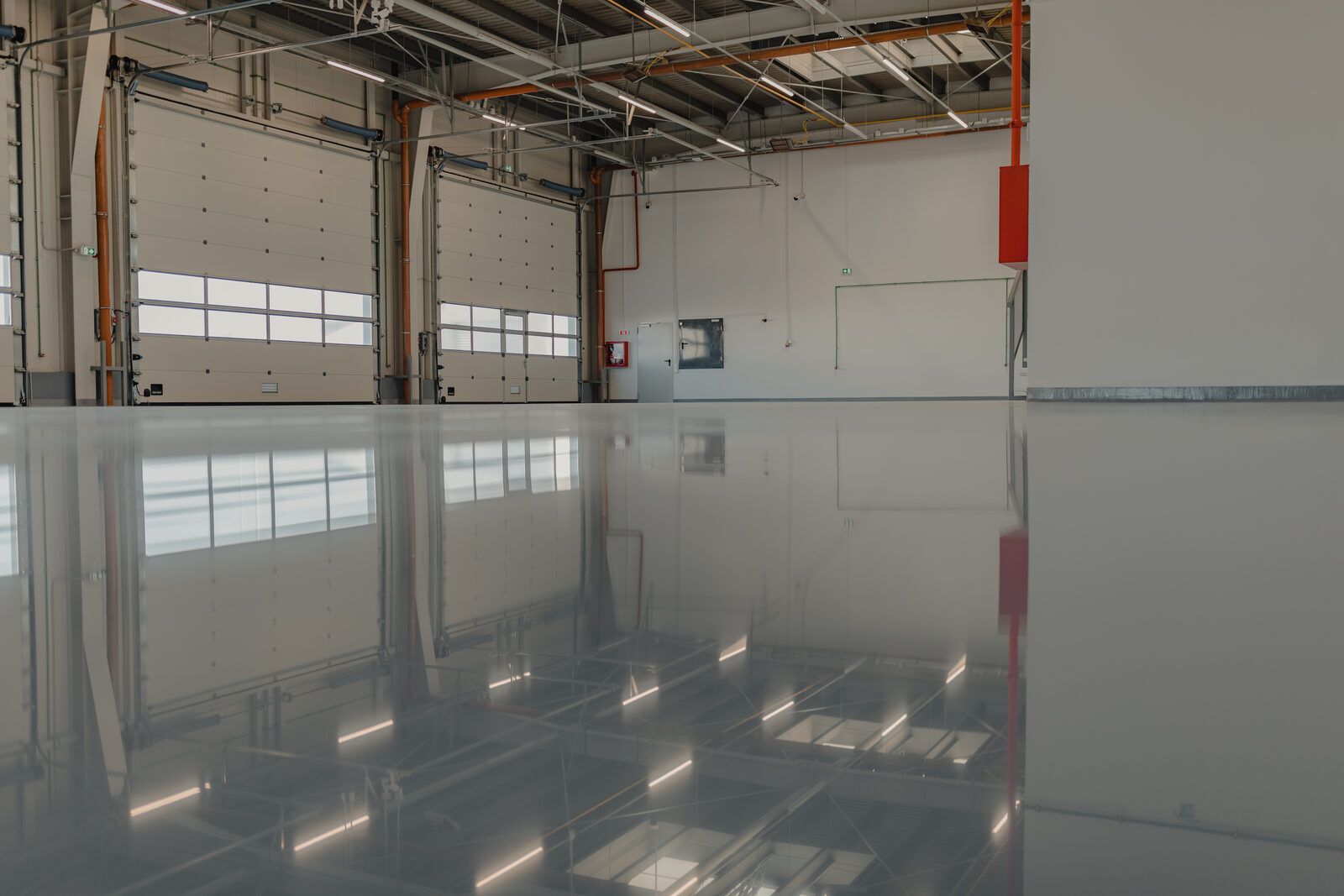 Clean industrial warehouse with a reflective gray epoxy floor